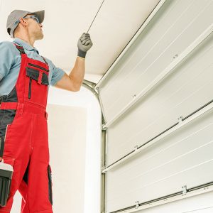 A technician works to repair a residential garage door.