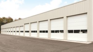The exterior of a commercial building with a long row of garage doors.
