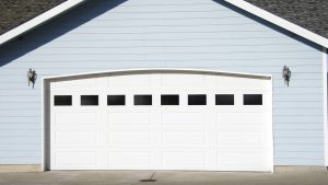 A house with blue siding and a white garage door with windows.